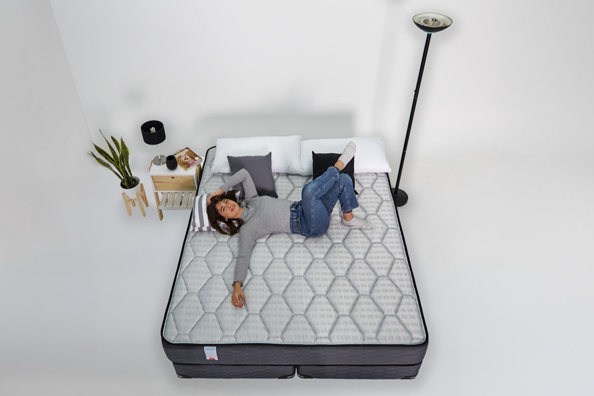 Woman stretched out on a bare mattress, giving it a real test