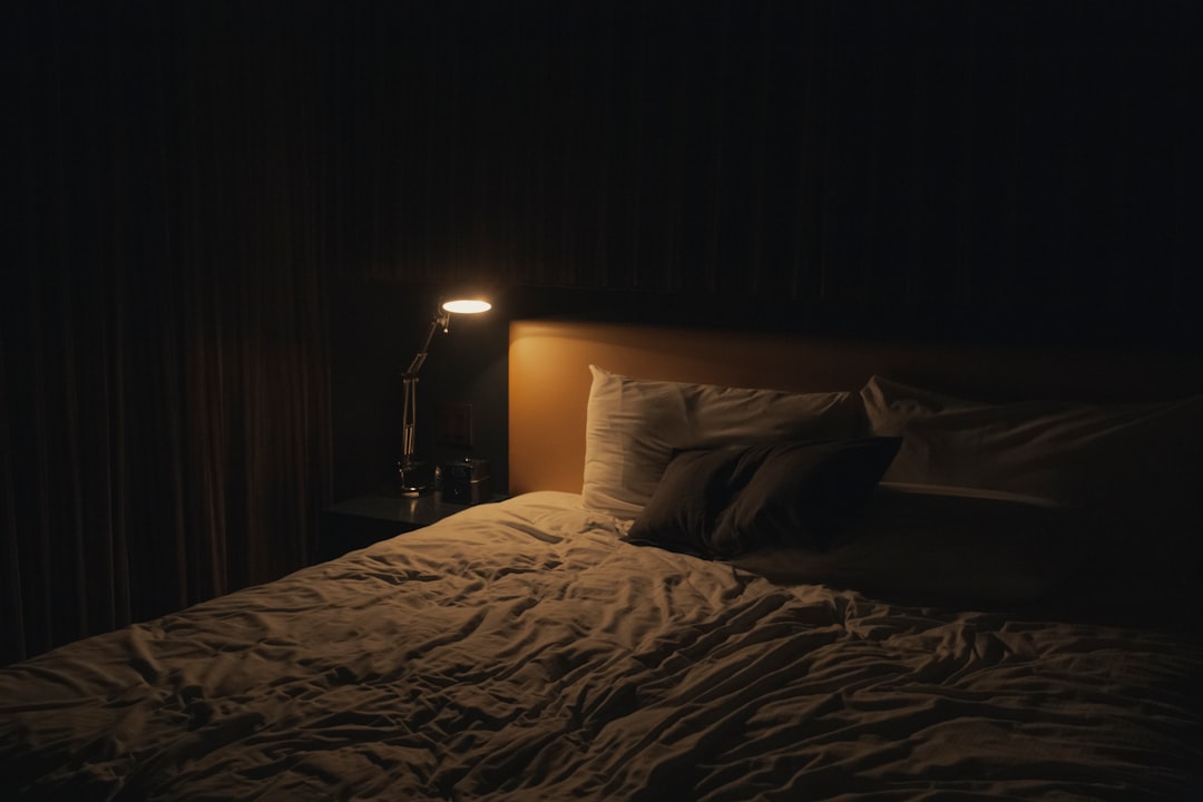 Bedroom lit softly by a bedside lamp in the evening