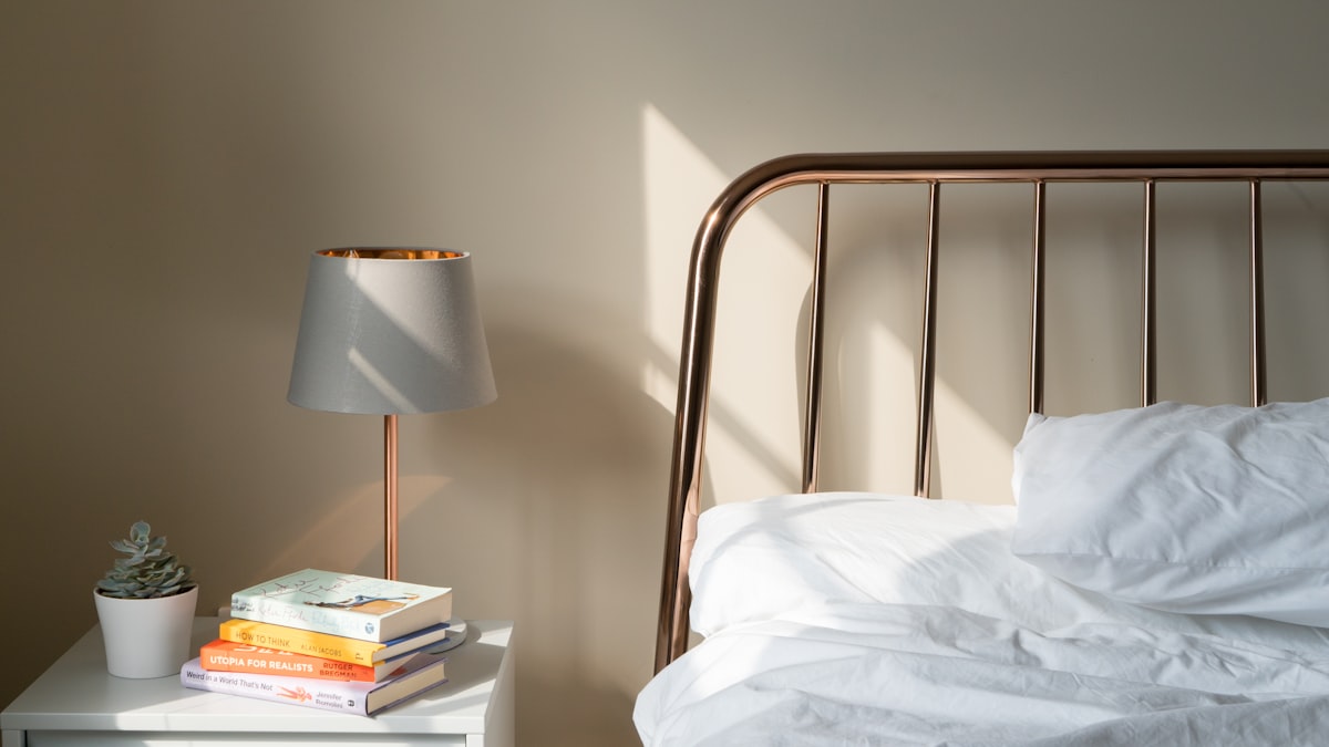 Bright bedroom with white bedding and a bedside lamp