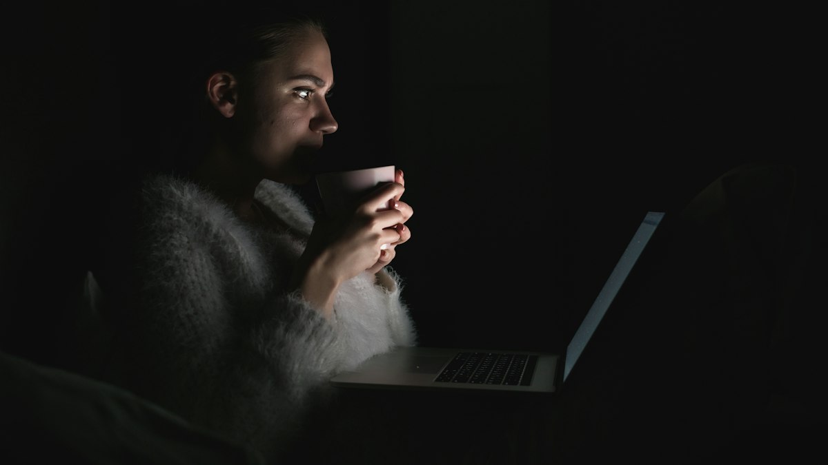 A woman awake late at night holding a mug