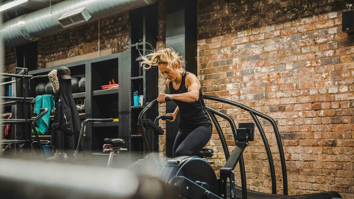 A woman training on a cardio machine in a gym
