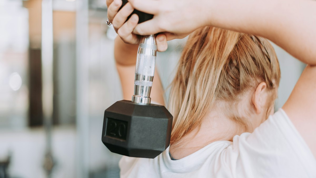 A hand gripping a dumbbell during a triceps extension