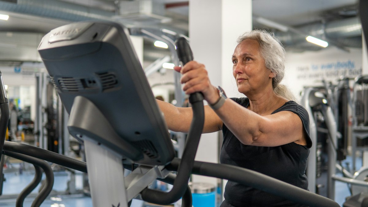 An older woman using a resistance machine at the gym