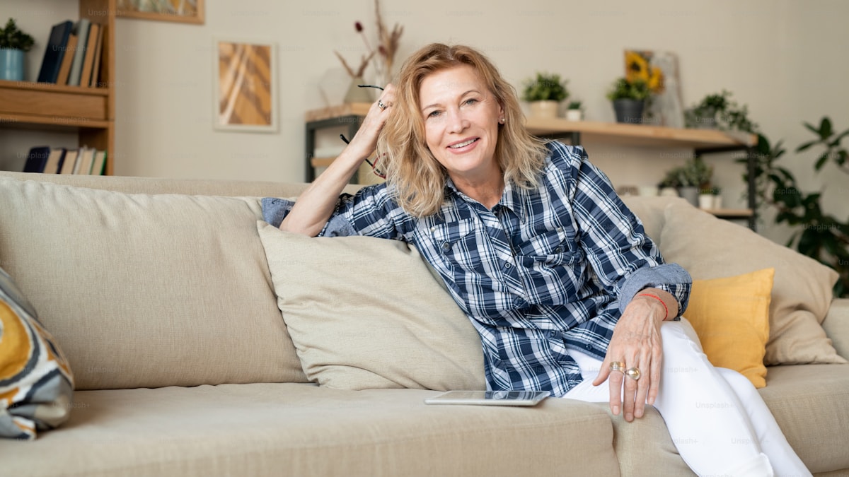 Cheerful mature woman relaxing on a couch at home