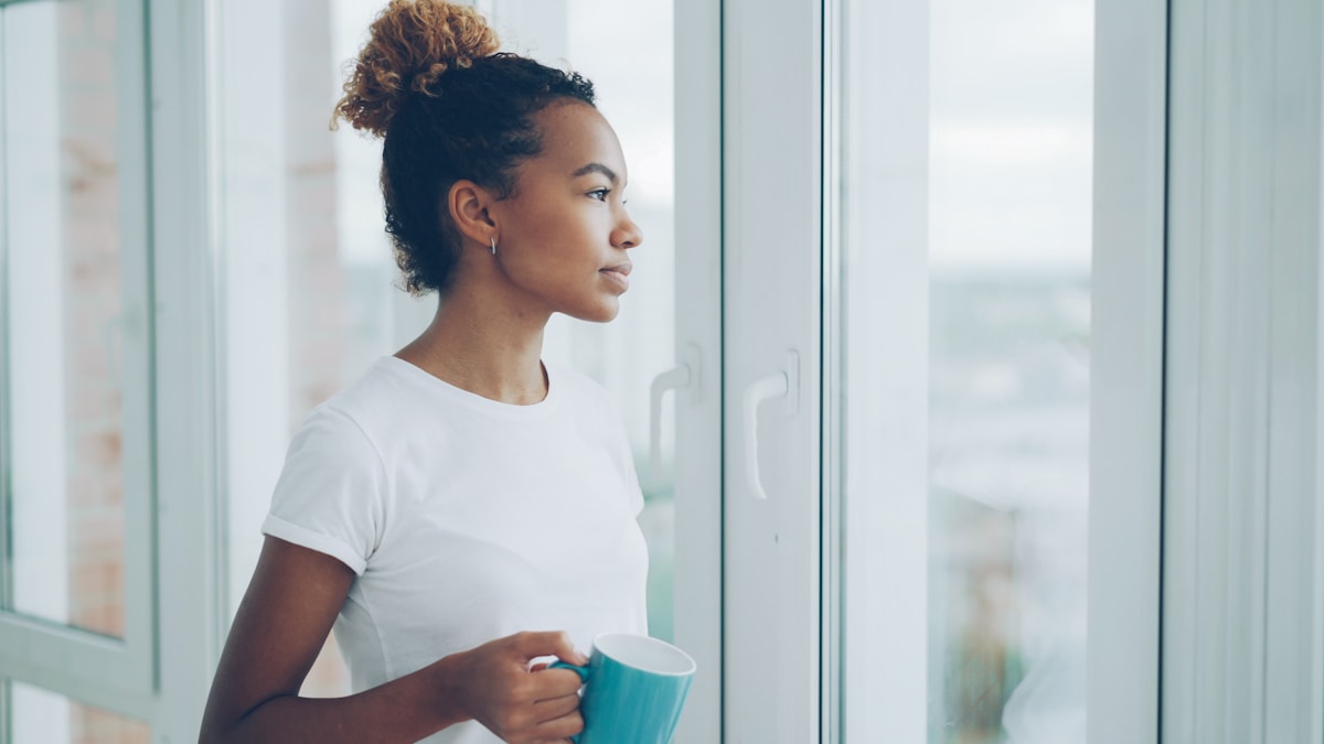 Woman holding a mug and looking out a window